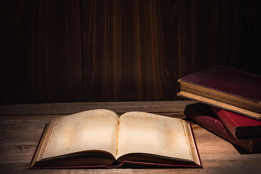 open old book neary stack of books on wooden table, vintage dark tone