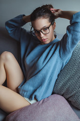 Sexy girl making hair bun on the couch