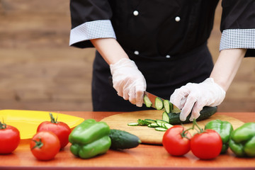 The cook cuts fresh farm vegetables