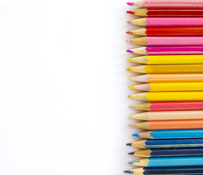 colored ground pencils on white background, rod close-up, pink, yellow, blue