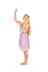 full length portrait of pretty blonde girl wearing purple fairy dress. standing pose, isolated on white studio background.