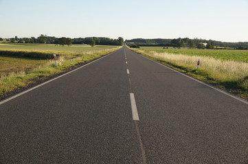 Local asphalt road running among farmland.