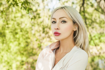Young woman face outdoors on green leaves background