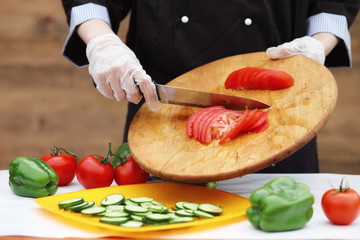 The cook cuts fresh farm vegetables