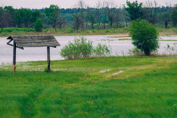 Flooded trees and meadows, wooden building on the background of the wild nature of Belarus,