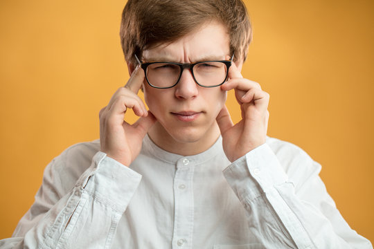 close up portrait of student with bad memory. try to memorise facts,datas. guy is trying to concentrate on work. man with headache