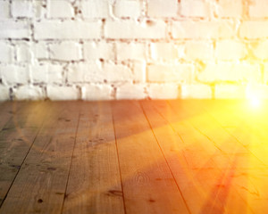 Black wooden floor and white brick wall background. Copy space with sun light halo. Toned