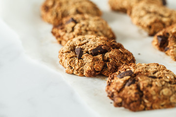 Vegan oatmeal cookies with chocolate on a light background. Healthy vegan dessert. Food blog style concept.