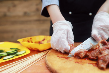 The cook cuts meat for cooking barbecue