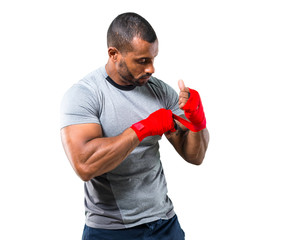 Strong sport man putting the boxing tapes on isolated white background