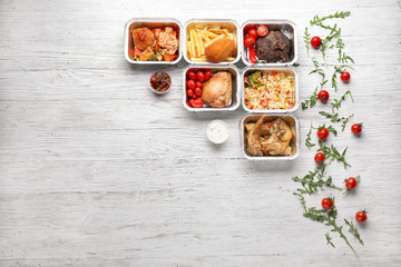 Containers with delicious food on wooden table. Delivery service