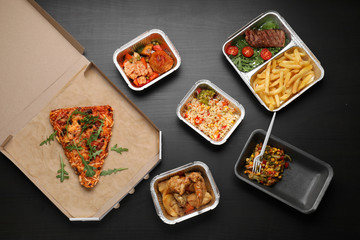 Different containers with delicious food on wooden table. Delivery service