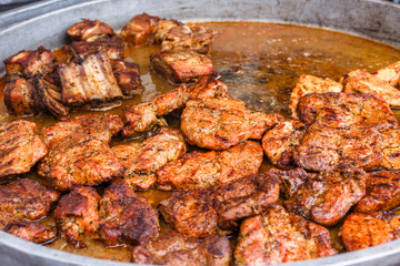 Festival of street food. Delicious fresh meat is fried in a large frying pan.