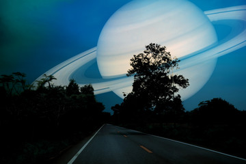 Obraz premium Saturn near earth on night sky over the country road
