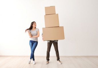 Young couple with boxes indoors. Moving into new house