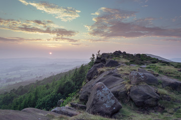 DESCRIPTION: Sunset lights the trees, heather and rocks at the Roaches, Staffordshire in the Peak District National park. 
