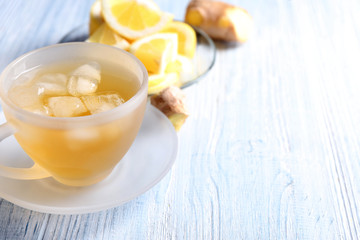 Cup of delicious tea with ice on wooden table