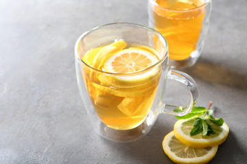 Glass cup of delicious tea with lemon on table