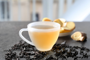 Cup of delicious tea with ginger  on table