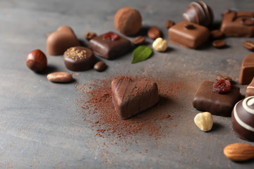 Different tasty chocolate candies on textured table