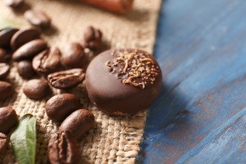Tasty chocolate candy with coffee beans on wooden table