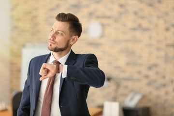 Businessman with wristwatch in office. Time management concept