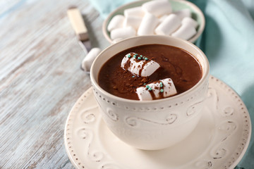 Cup of yummy hot chocolate with marshmallow on wooden table
