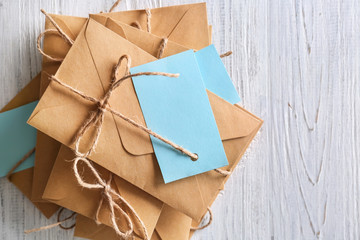 Brown envelopes with tags on wooden background, top view. Mail service