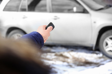 Young woman using car alarm outdoors