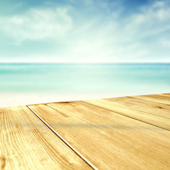 Tropical Beach Background with Sand, Blue Sky and Sea – Wooden table or deck and Copy Space for...