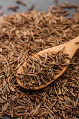 Seeds of cumin on a dark stone background