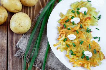 Fried potato pancakes or draniki with sour cream and green onion. The national dish of Belarus, Ukraine and Russia.