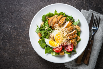 Caesar salad with chicken breast and tomatoes.