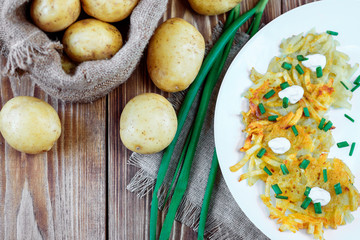 Fried potato pancakes or draniki with sour cream and green onion. The national dish of Belarus, Ukraine and Russia.