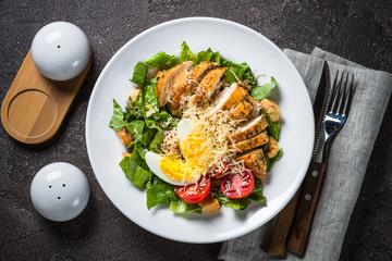 Caesar salad with chicken breast and tomatoes.