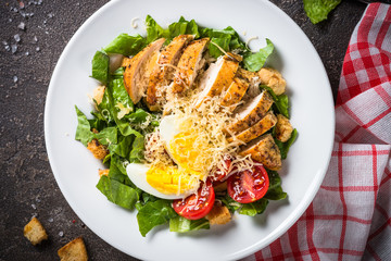 Caesar salad with chicken breast and tomatoes.