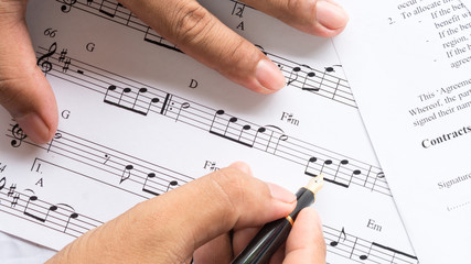 song composer working on music note paper