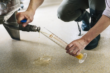 Brewery worker examining beer in beaker