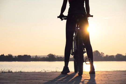 Silhouette of a girl near sea on the bike. Sport and active life concept