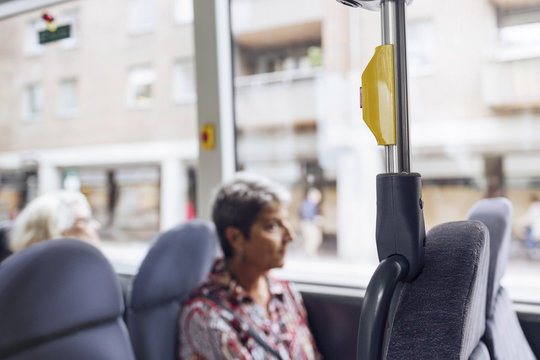 Woman sitting in bus and looking through window