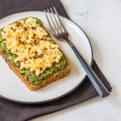 Scrambled eggs on whole wheat bread with avocado