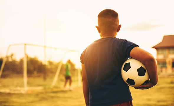 An action sport picture of a group of kid playing soccer football for exercise in before the sunset. Picture with copy space for world cup concept.