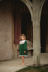 Pretty little girl in stylized old fashion dress walking on the streets of an old English Fort in North America