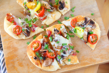 Overhead of naan pizza on cutting board