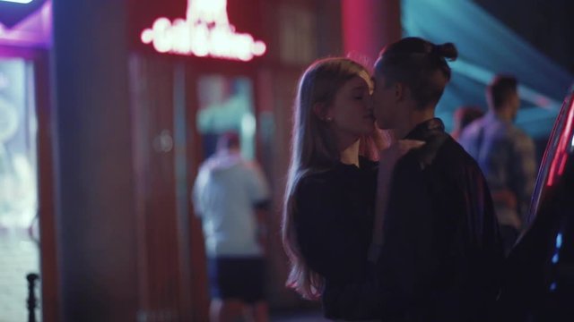 Romantic young couple standing by their car and passionately kissing. True feelings, having a date, enjoying each other. Love story, outdoors, night time
