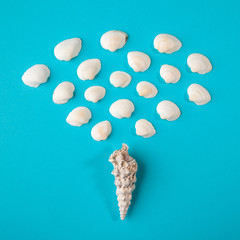 Seashell of cone shape with many little seashells on blue paper background
