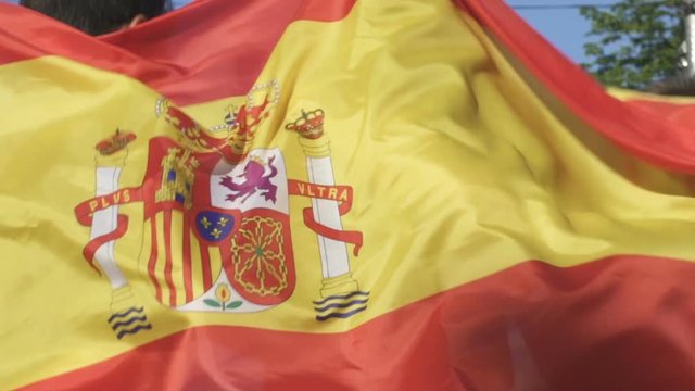 Cheerful Spanish friends actively jumping supporting national team, slow-mo