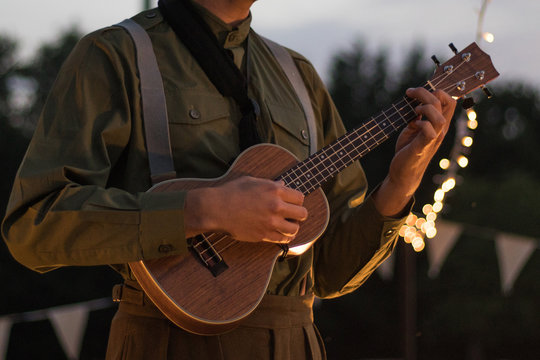 Man Playing A Ukulele Outside On A Summers Evening