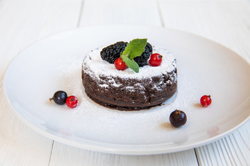 Chocolate fondant lava cake decorated with strawberries and powdered sugar