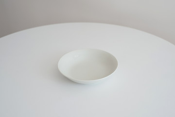 Fototapeta premium White plate stands on a white round table